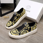Versace luxury sneakers pair, black-and-yellow patterned uppers with black laces and white sole
