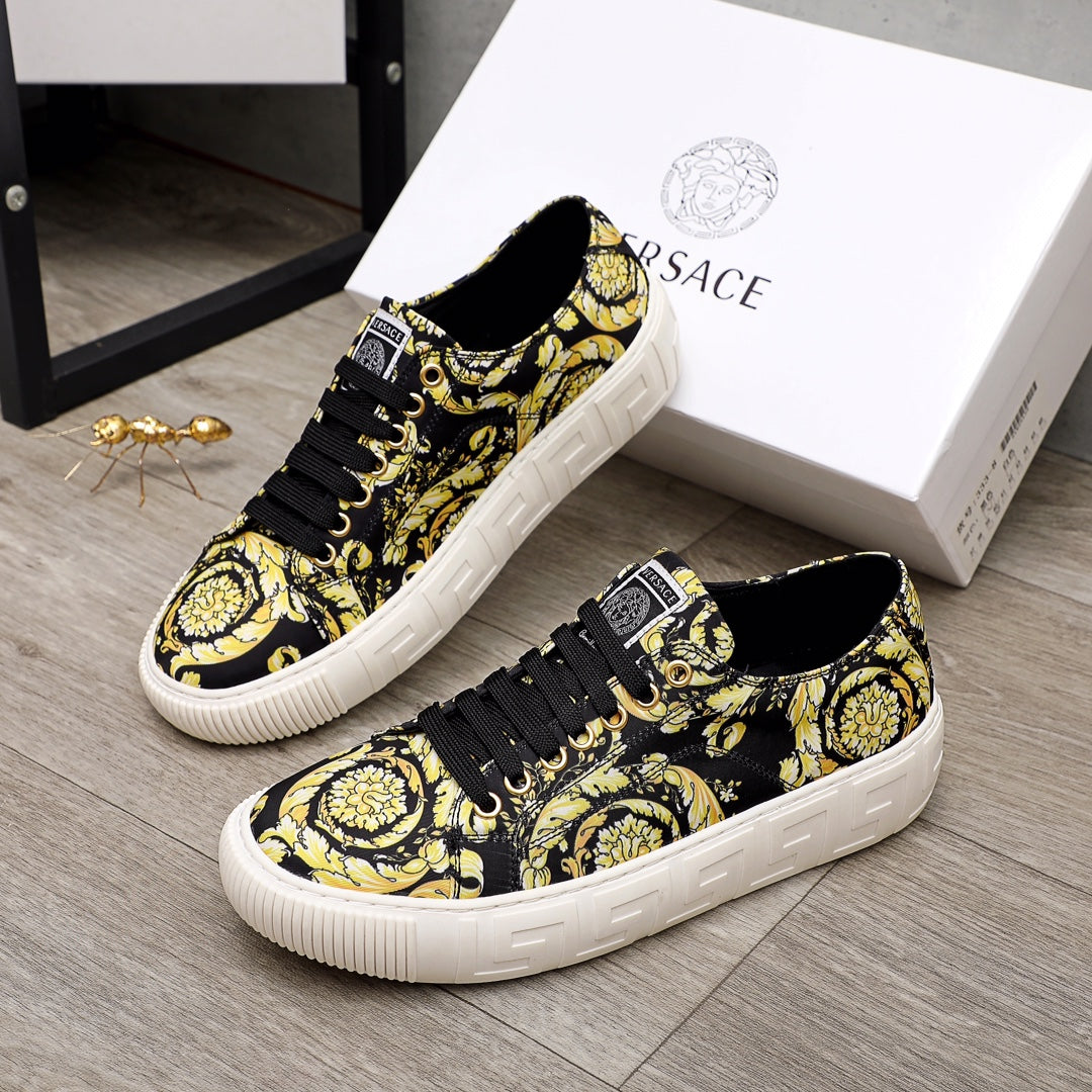 Versace luxury sneakers pair, black-and-yellow patterned uppers with black laces and white sole