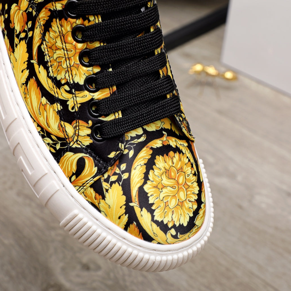 Versace luxury sneaker upper close-up, black with gold baroque pattern, black lace-up