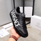 Black low-top sneakers with oversized white side lettering and lace-up closure