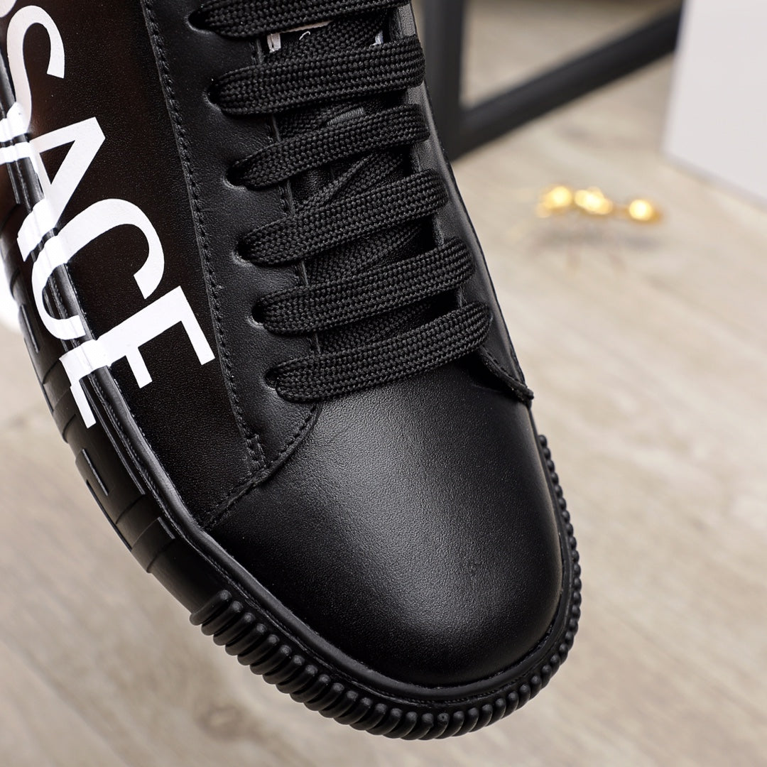 Close-up of black lace-up sneaker with textured stitching and black rubber sole