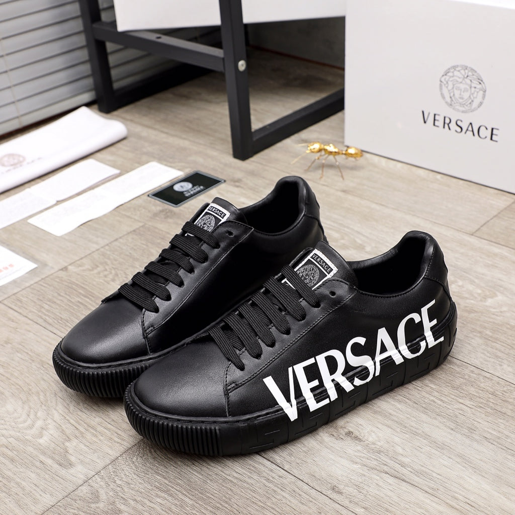 Black lace-up sneakers with large white VERSACE logo on the side