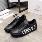 Black lace-up sneakers with large white VERSACE logo on the side