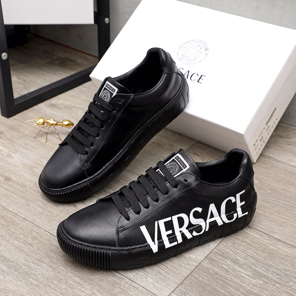 Black lace-up sneakers with white VERSACE lettering and chunky rubber sole