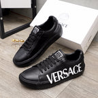 Black lace-up sneakers with white VERSACE lettering and chunky rubber sole