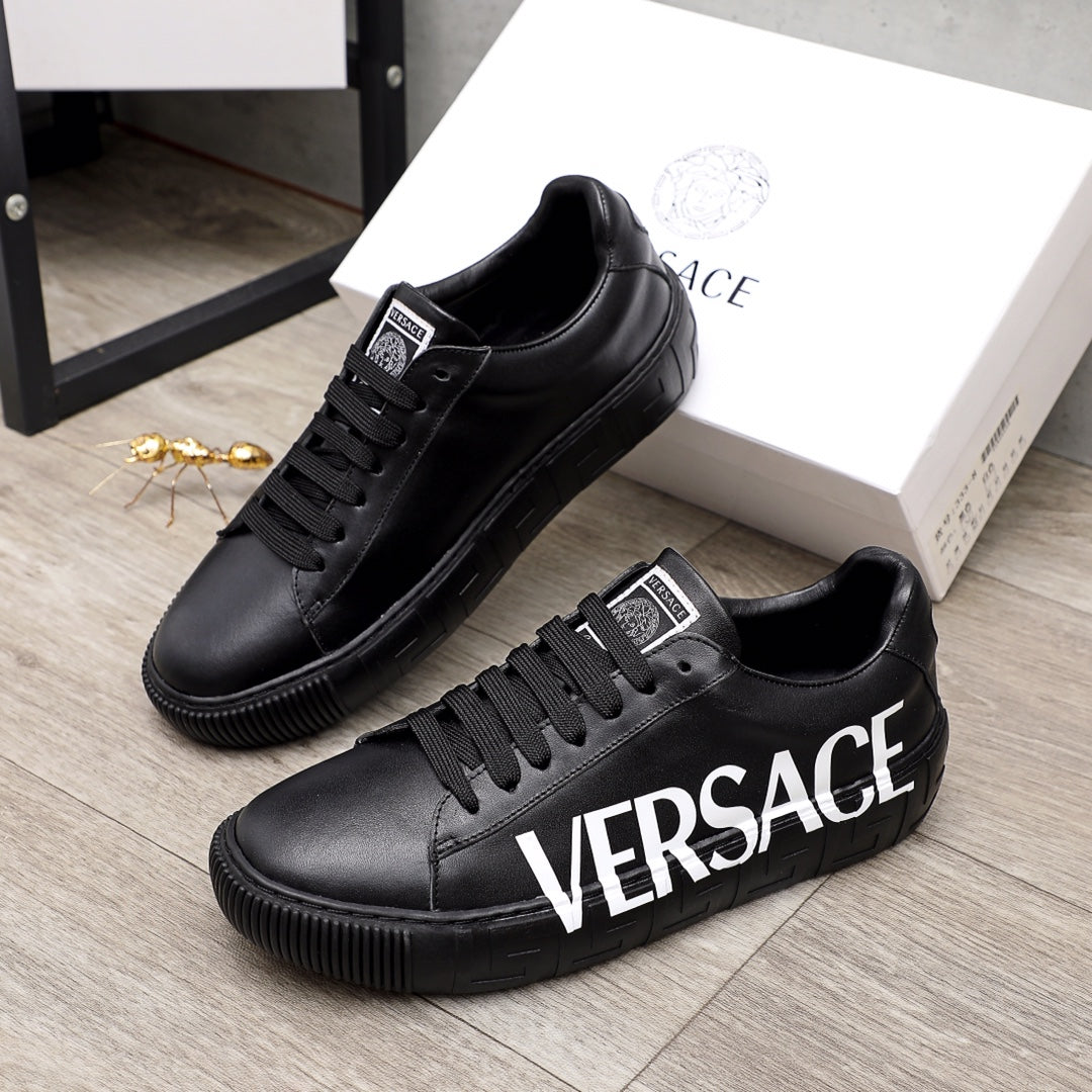 Black lace-up sneakers with white VERSACE lettering and chunky rubber sole