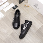 Black sneakers with white VERSACE logo on the side, shown with pair view