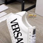 White Versace sneakers close-up with large black VERSACE logo on heel panel
