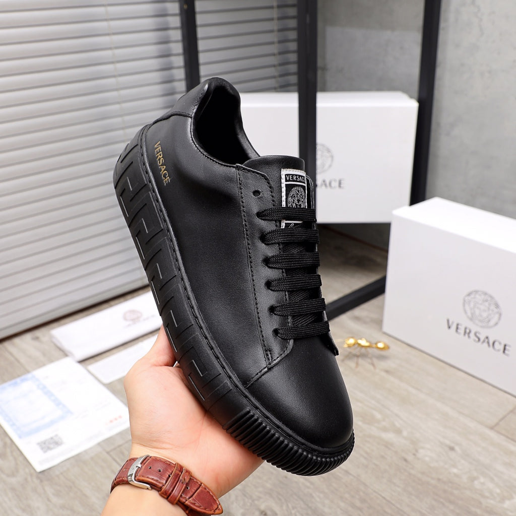 Versace black leather sneakers, side view with lace-up closure and thick sole
