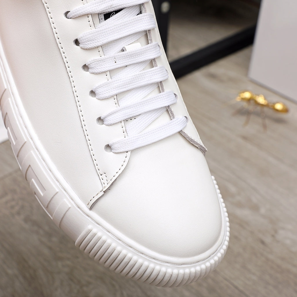 White Versace sneaker close-up with lace panel, stitching, and textured platform outsole