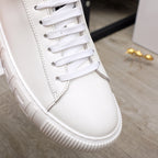 White Versace sneaker close-up with lace panel, stitching, and textured platform outsole