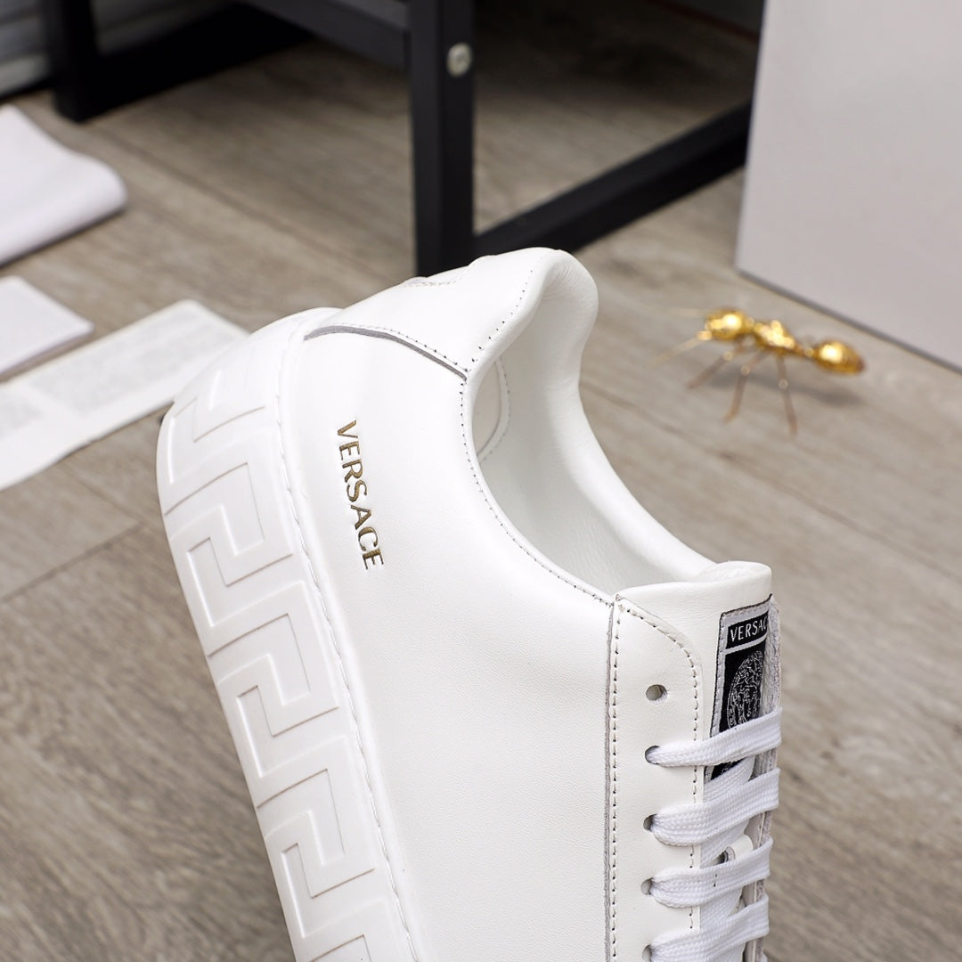 Versace white sneaker side view with embroidered logo text and lace-up closure