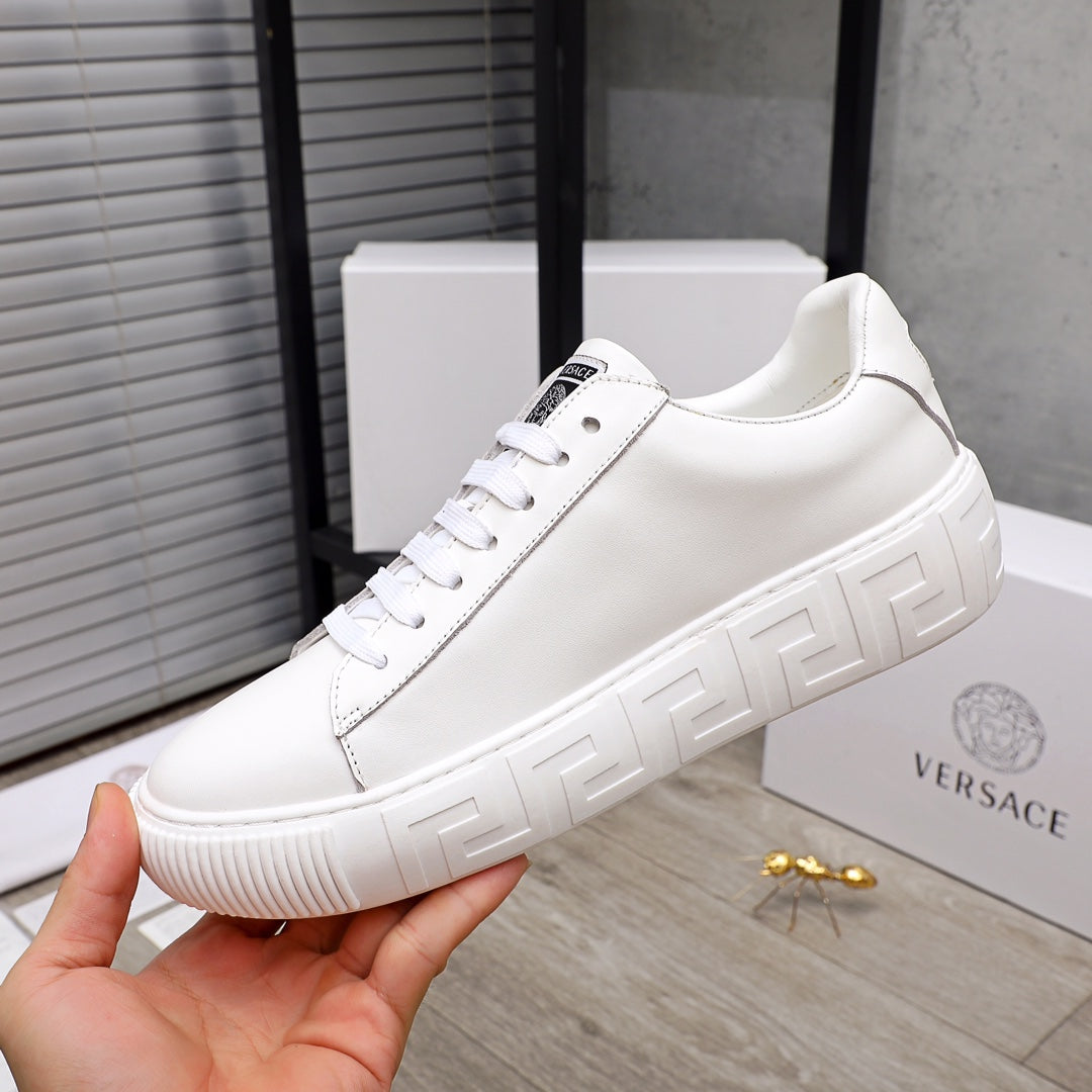 Versace white lace-up sneaker on hand view, showing front strap and chunky platform sole