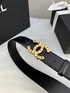 Chanel belt close-up: dark embossed strap with gold-tone circular logo buckle