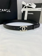 Chanel belt with dark textured strap and round gold-tone logo buckle