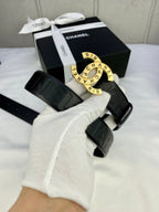 Chanel belt on arm: dark embossed strap with round gold-tone CHANEL buckle