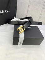Chanel belt with dark strap and round gold-tone buckle centered on logo