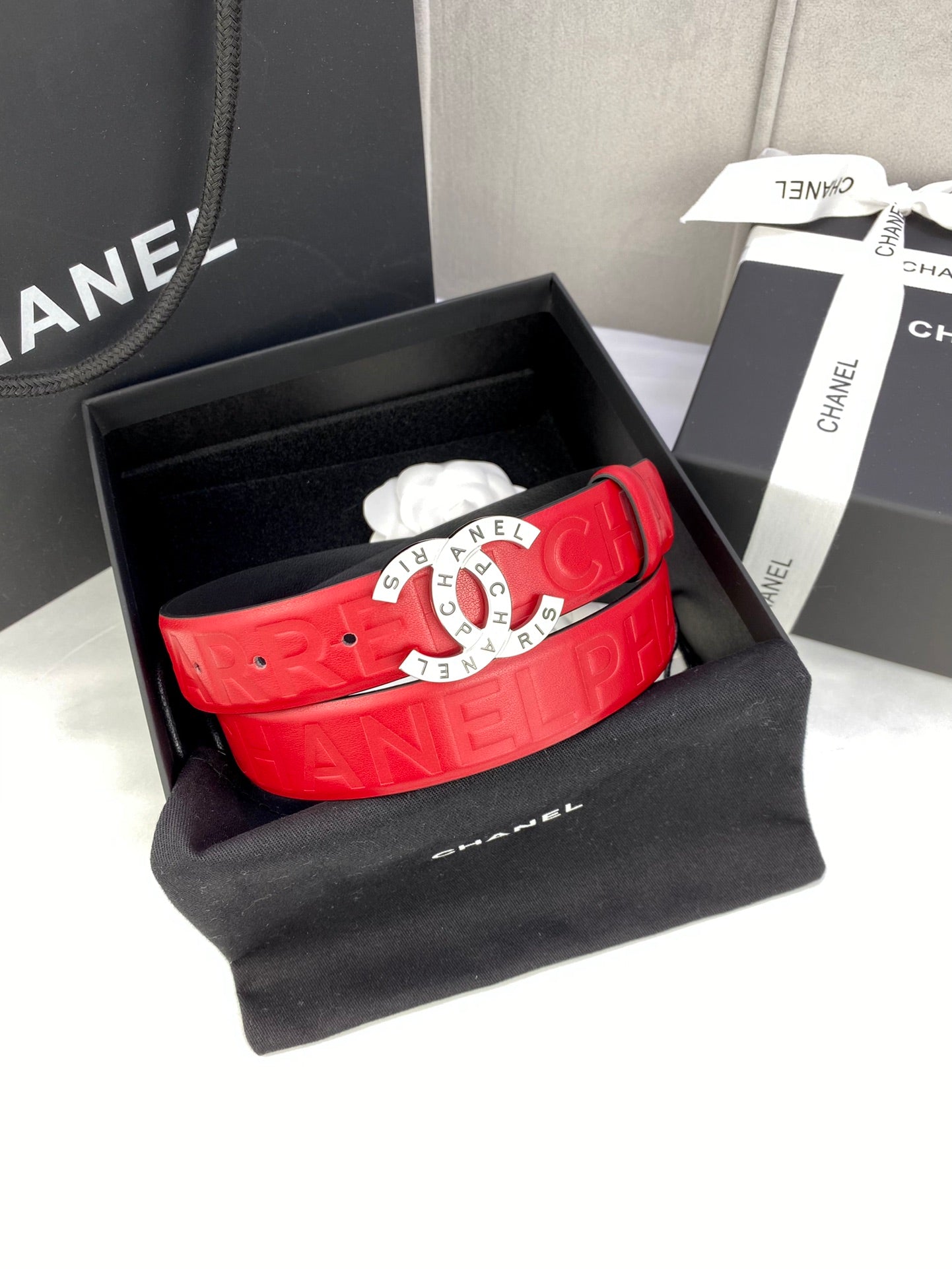 Red Chanel belt in black gift box, embossed strap with gold circular CHANEL buckle