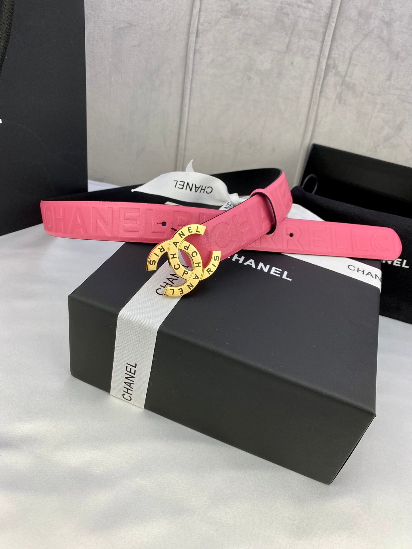Pink Chanel belt with gold circular Chanel logo buckle and strap loops