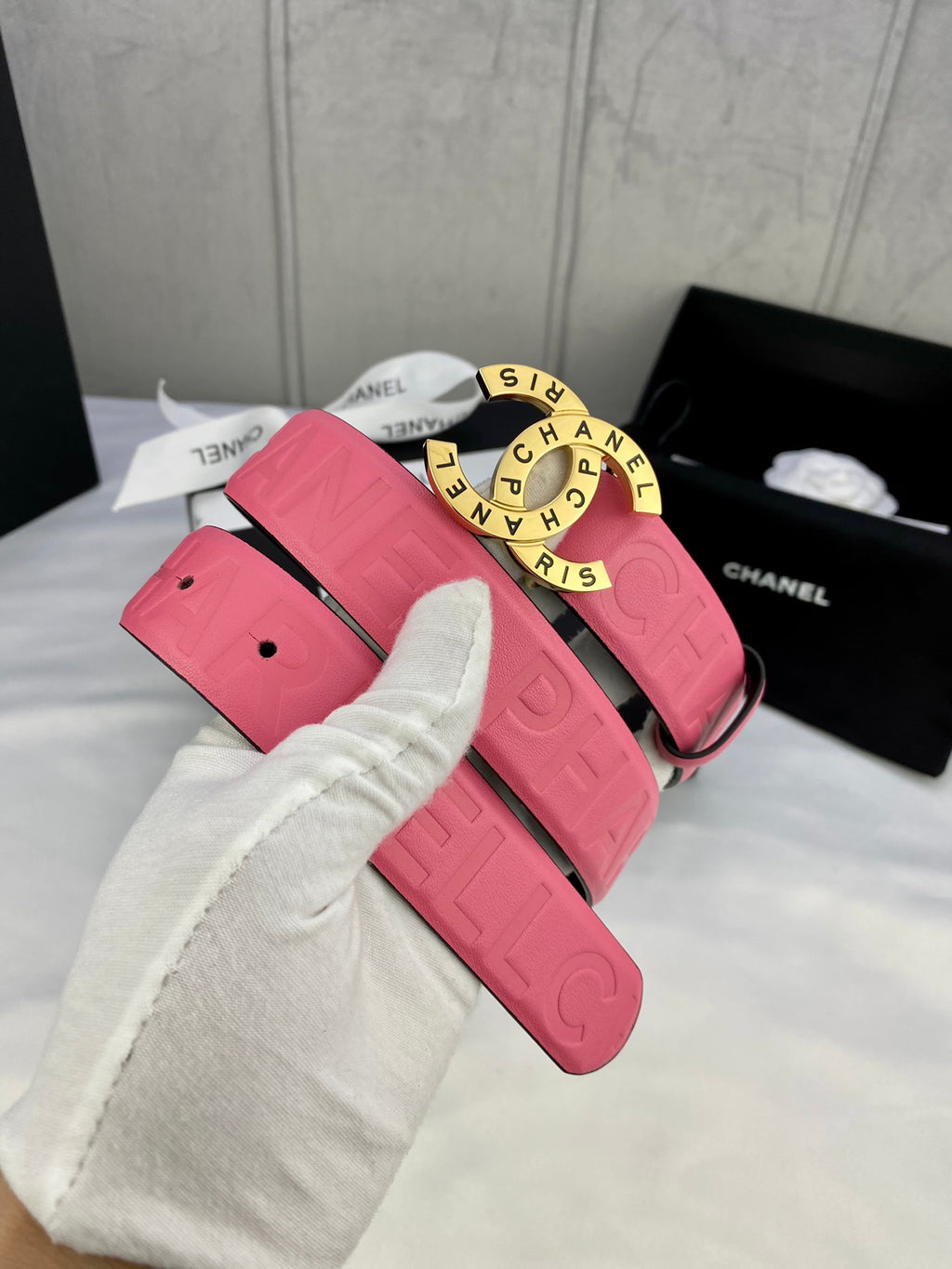 Pink Chanel belt with gold round logo buckle and adjustable strap holes