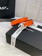 Chanel belt with orange strap and gold-tone round logo buckle on box