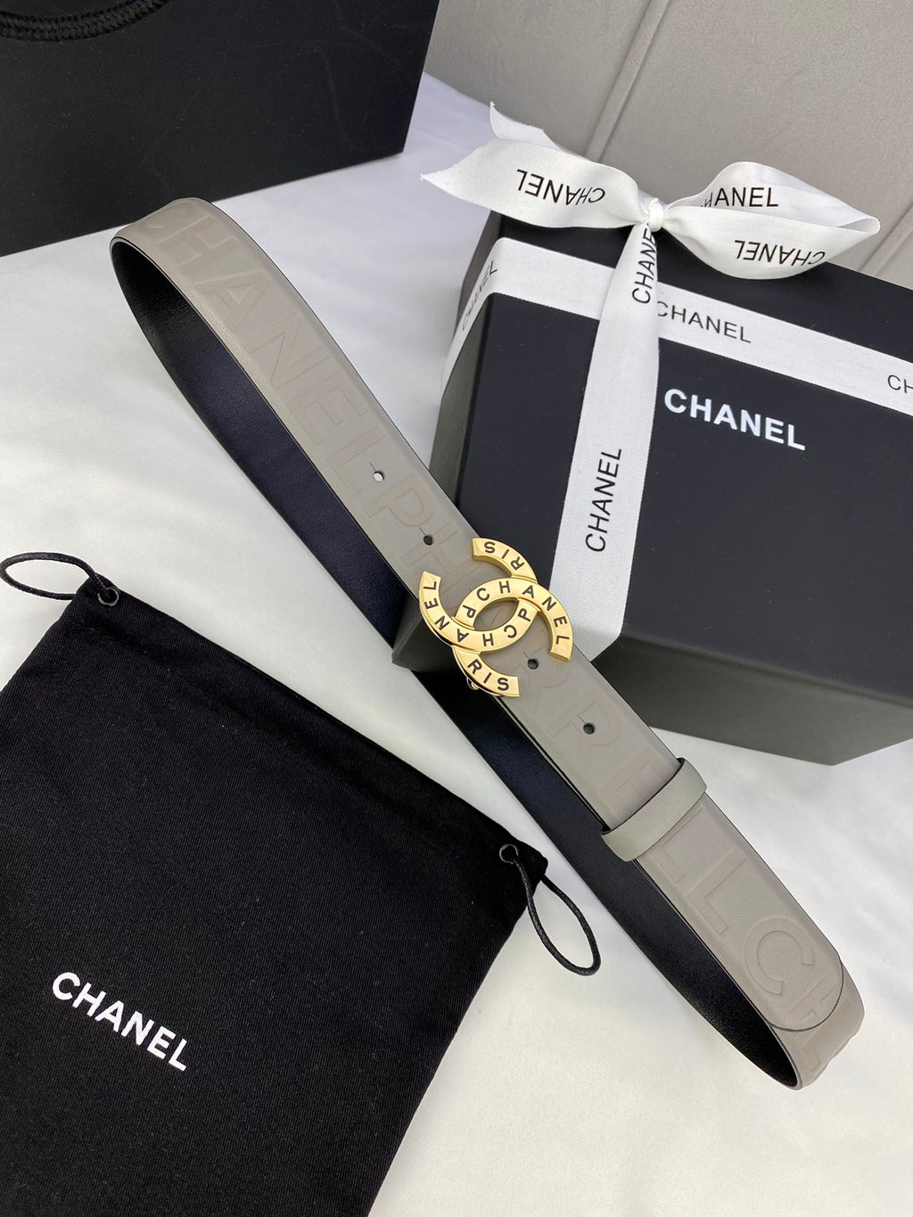 Beige Chanel belt with round logo buckle and adjustable embossed strap in box
