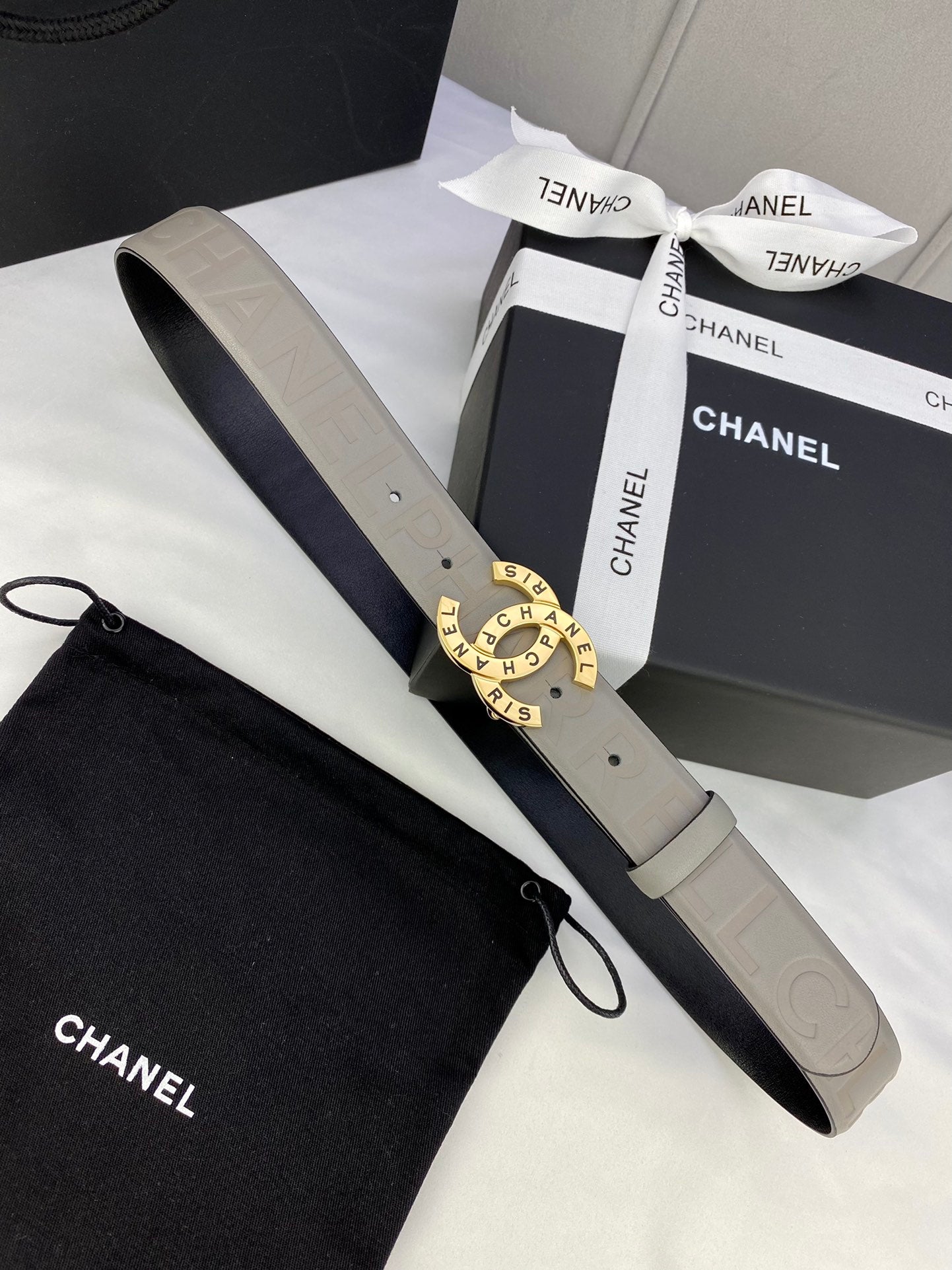 Beige Chanel belt with round logo buckle and adjustable embossed strap in box
