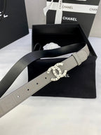 Light beige Chanel belt on box with circular logo buckle and embossed strap pattern