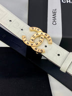 Close-up Chanel belt buckle: gold circular CHANEL logo on white embossed strap