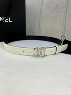 White Chanel belt with circular gold logo buckle, strap holes and embossed lettering