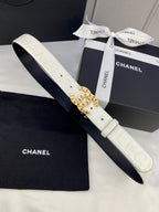 White Chanel belt with circular gold buckle and matching dark strap, flat lay