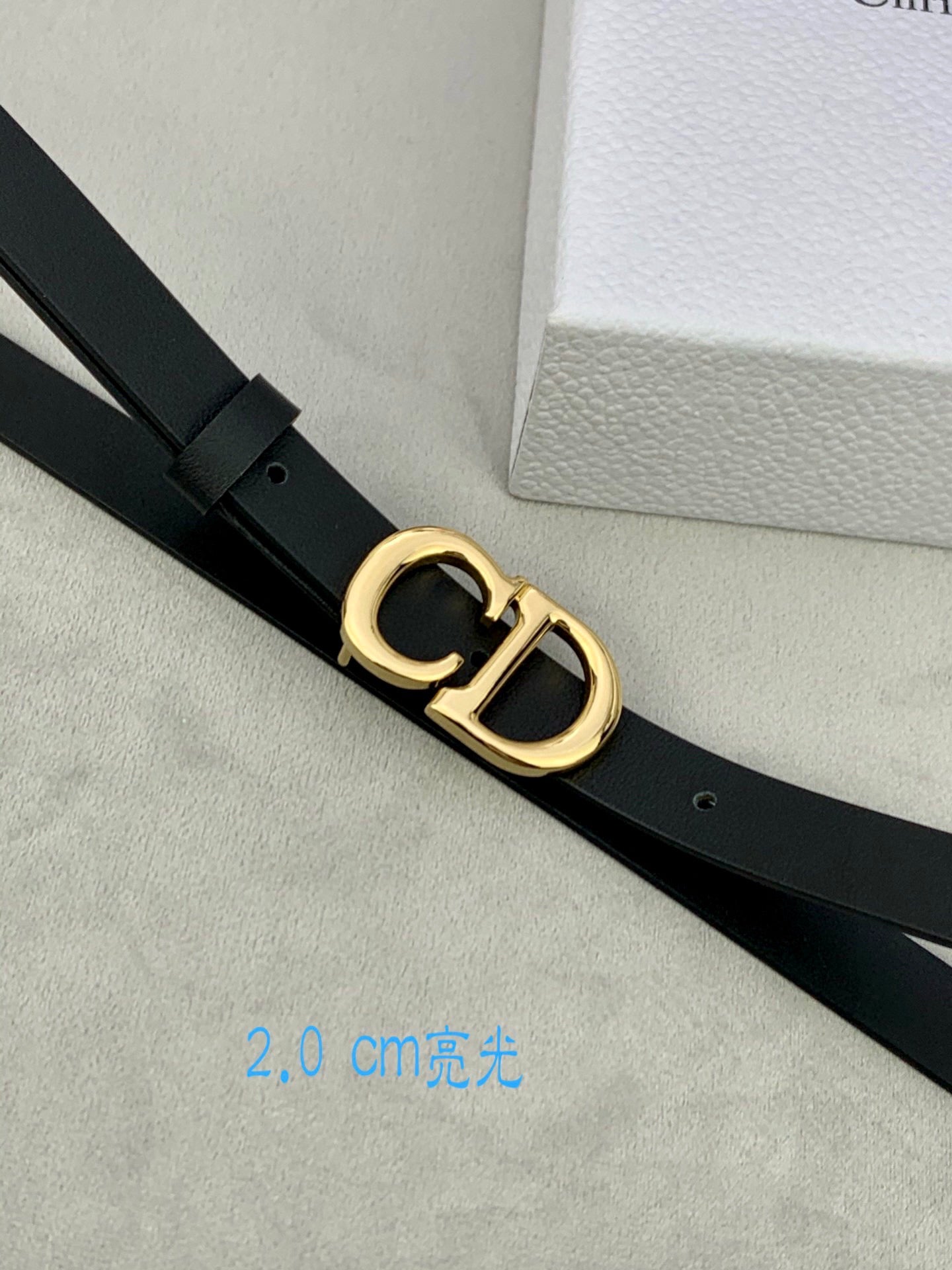 Black leather belt with gold-tone double D buckle, close-up
