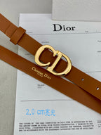 Tan leather belt with gold-tone CD buckle and rivet holes