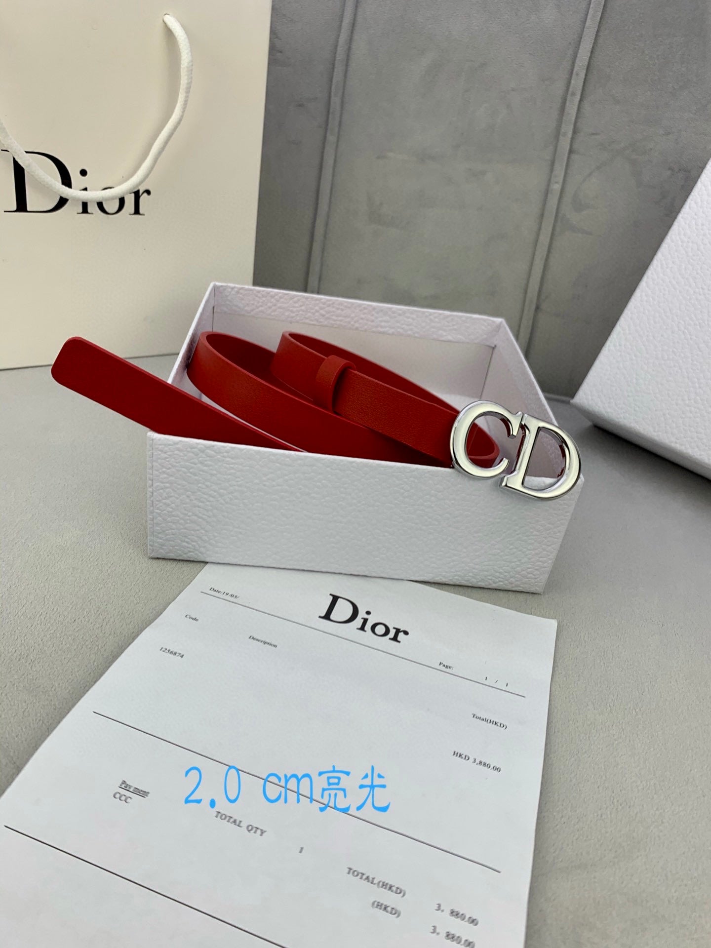 Dior red belt with CD buckle inside a white gift box