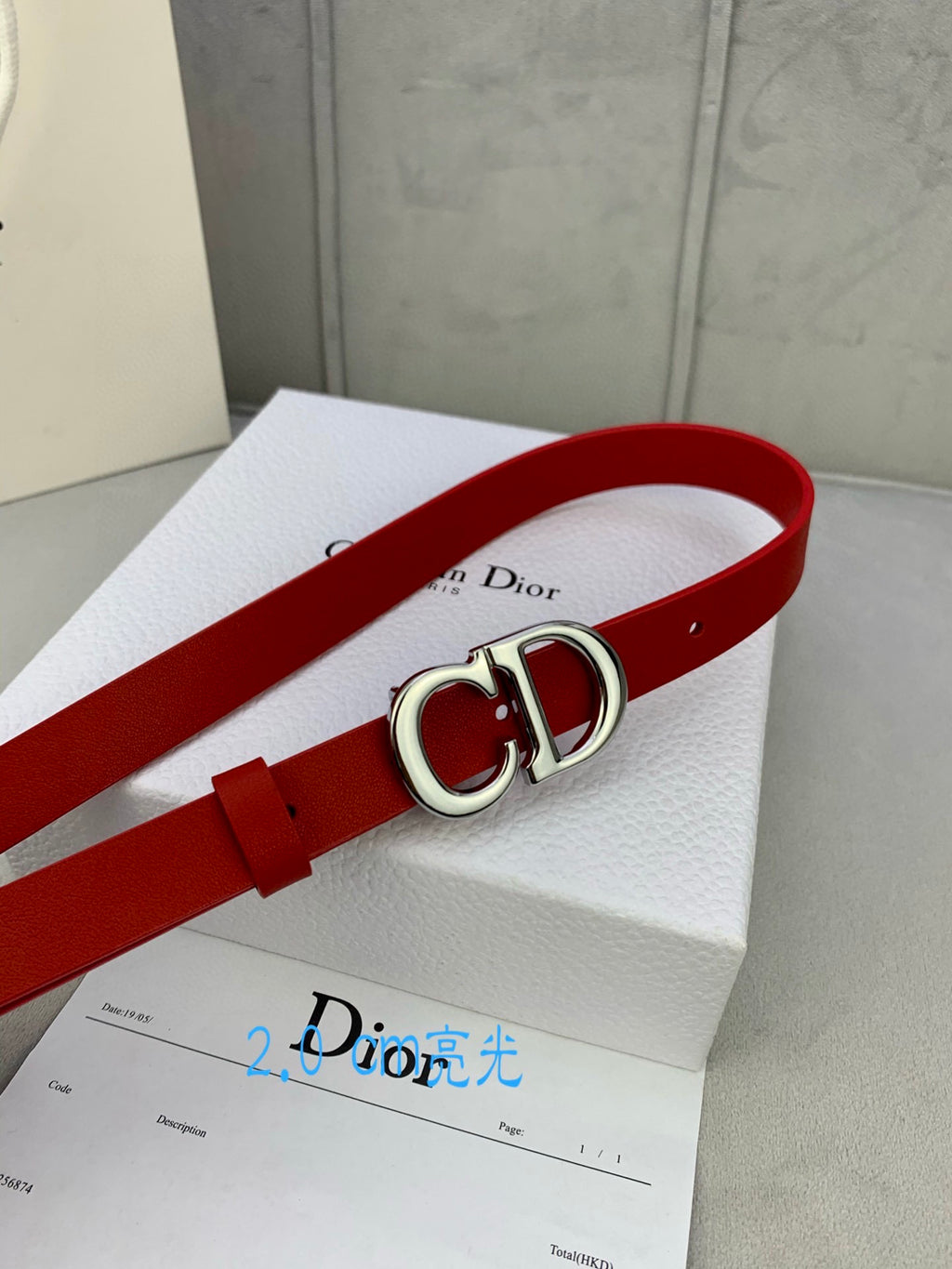 Dior red belt with CD buckle on white dust bag