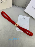 Dior red belt with CD buckle lying flat on a surface