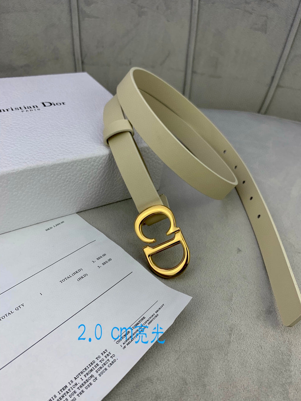 Beige belt with gold-tone CD buckle, open view of strap and belt holes