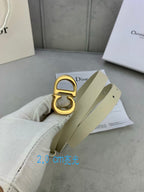 Beige belt with gold-tone CD buckle shown close-up with strap end
