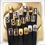 Assorted Prada belts in black with different buckle designs shown in a display set