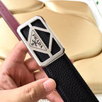 Prada belt with black leather texture, burgundy stripe, and silver logo buckle close view