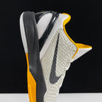 Nike basketball shoe side view with white textured upper, yellow trim, black swoosh, gray heel