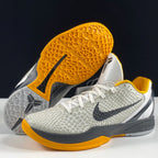 Nike basketball shoes with yellow outsole traction and white textured uppers, gray midsoles