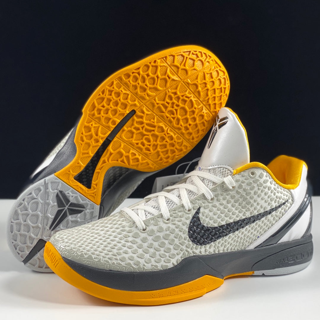 Nike basketball shoes with yellow outsole traction and white textured uppers, gray midsoles