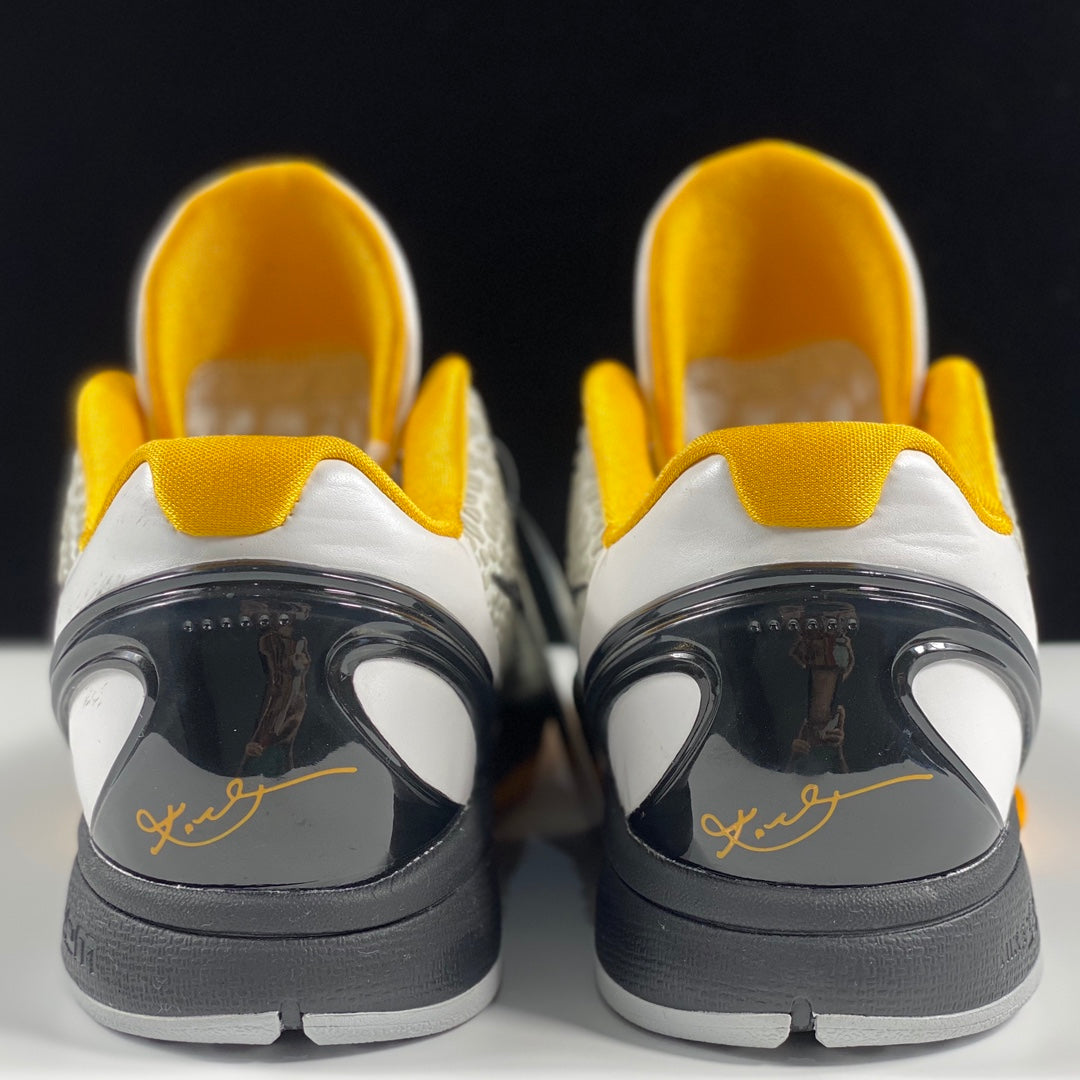 Nike basketball shoes heel view with white uppers, yellow lining, dark heel pods, gray soles