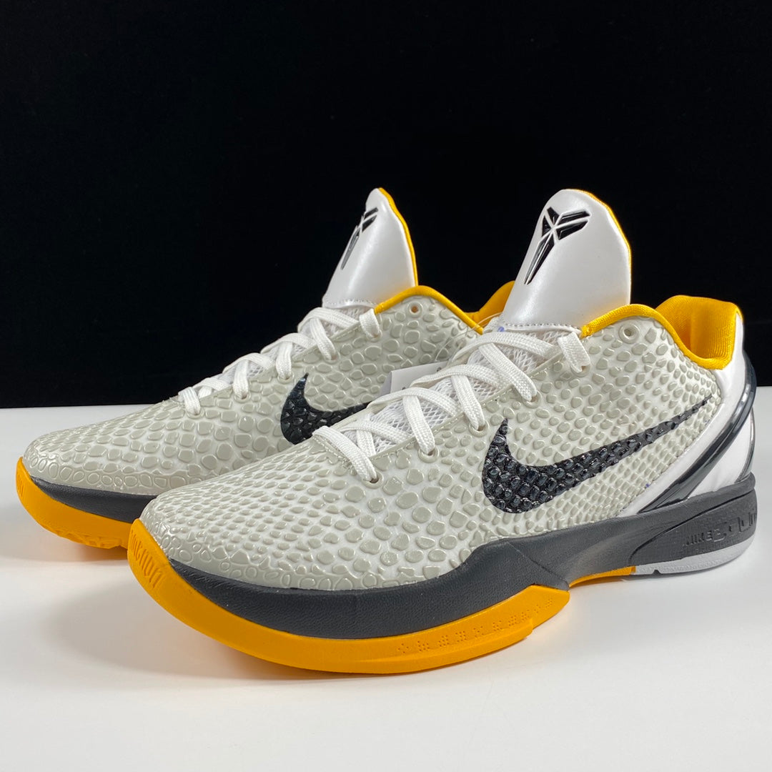 Nike basketball shoes pair with white textured uppers, yellow lining, black swooshes, gray sole