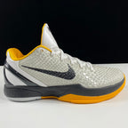 Nike basketball shoes with white textured knit, yellow collar, black swoosh, gray sole
