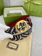 Gucci belt close-up on dust bag, navy GG canvas strap, red underside, gold interlocking buckle.