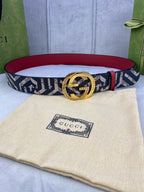 Gucci belt with navy and beige GG logo canvas strap, gold buckle and red lining.