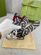 Gucci belt on dust bag, navy GG canvas strap with red lining and silver-toned buckle.