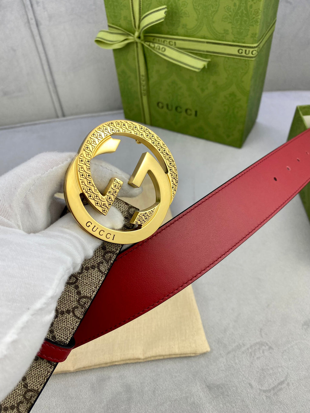 Gucci belt with red leather side and gold double-G buckle on GG canvas